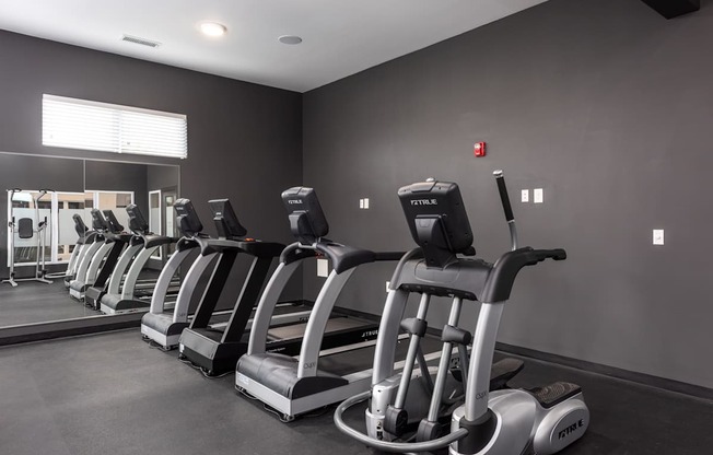 A gym with treadmills lined up.