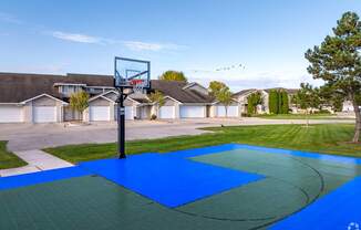 A basketball court with a hoop and a blue surface.