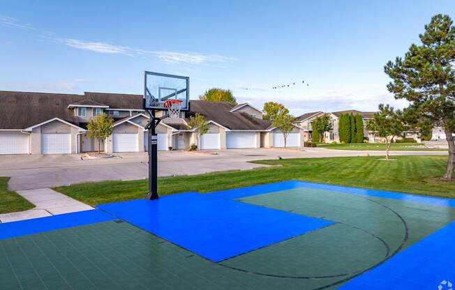 A basketball court with a hoop and a blue surface.