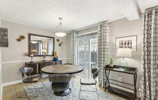 A living room with a round table and chairs.