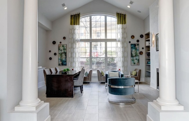 a living room with a large window and a table and chairs