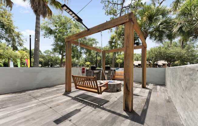 a swing bench in the backyard of a house