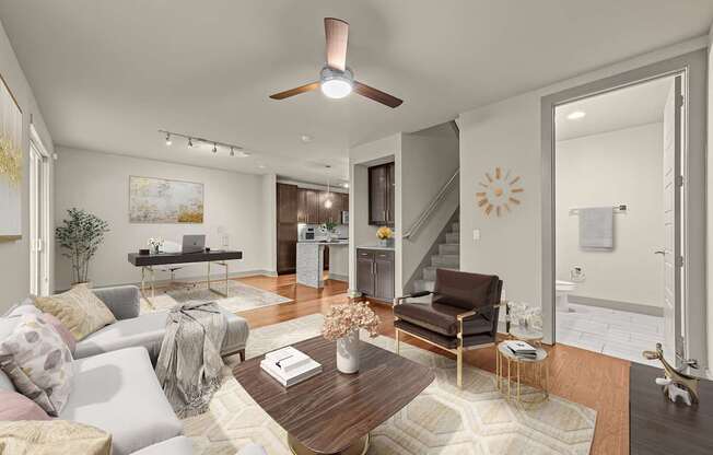A living room with a couch, a coffee table, and a ceiling fan.