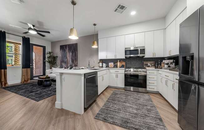 A modern kitchen with white cabinets and stainless steel appliances.