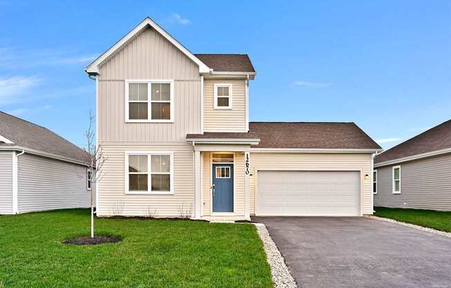 A house with a blue door and a grey garage door.