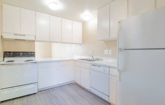 a white kitchen with white appliances and white cabinets