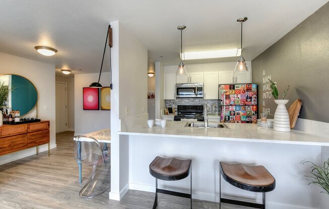 Kitchen and Bar Seating with Hardwood Inspired Floor, Decorated Refrigerator, and 
