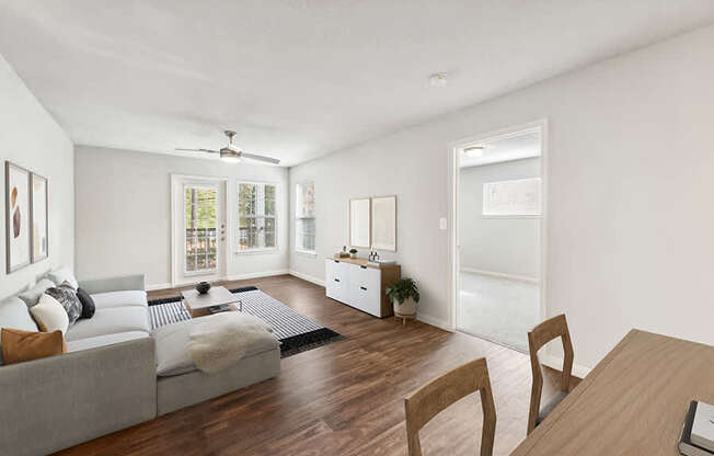 Model Living Room with Wood-Style Flooring and Patio Accessibility at Lake Cameron Apartments located in Apex, NC.