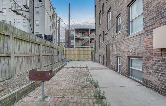 a back alley with brick buildings and a rusty mailbox