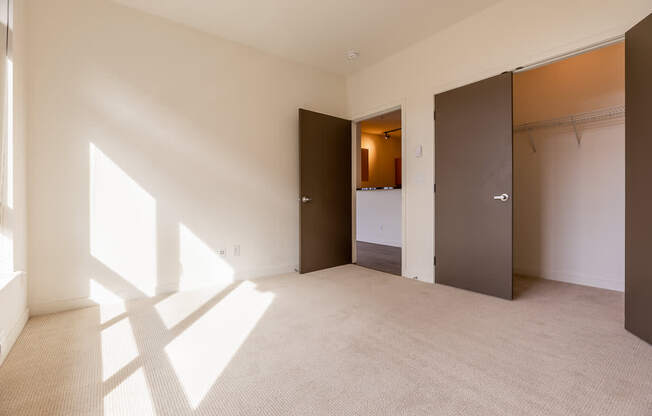 A room with a carpeted floor and a large window on the left side.