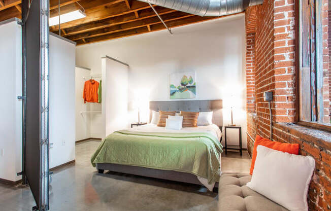 a bedroom with a bed and a exposed brick wall