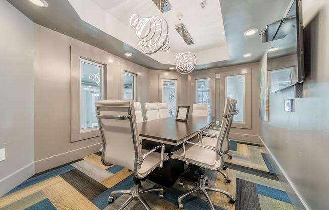 a conference room with a long table and chairs and a flat screen tv on the wall
