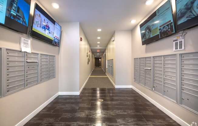 a hallway with mailboxes and televisions in a building