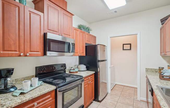 A kitchen with brown cabinets and black appliances.