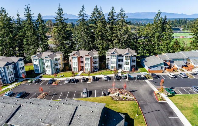 an aerial view of an apartment complex with parking lot and trees at Woodcreek, Washington, 98370