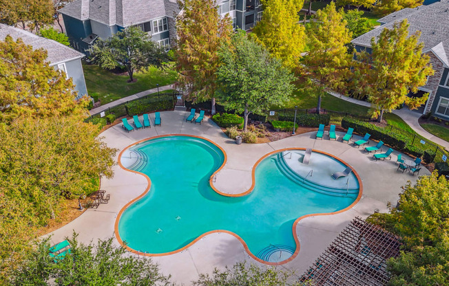 an aerial view of a swimming pool with chairs around it