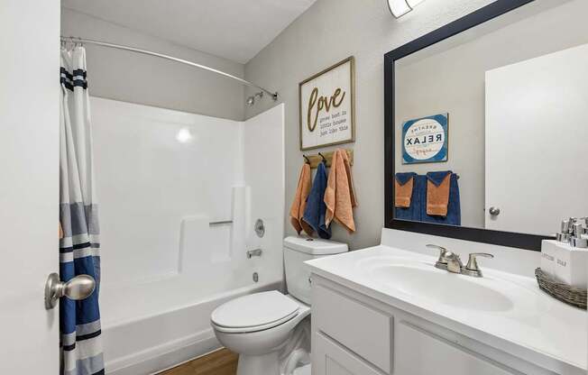 A white toilet sits next to a white sink in a bathroom.