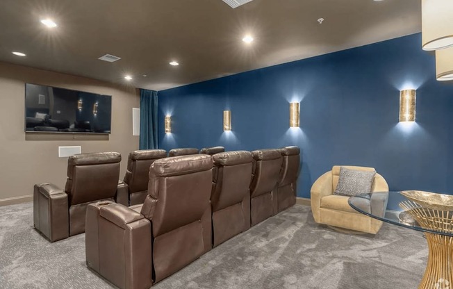 A room with brown leather chairs and a grey carpet.