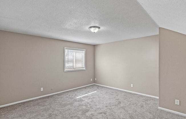 an empty room with carpet and a window