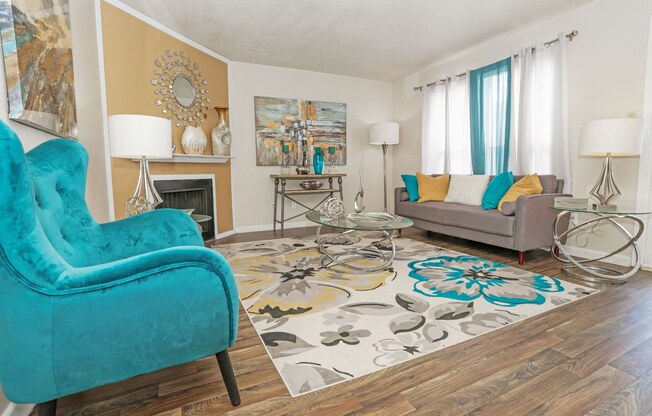 A living room with a blue chair and a grey couch at The Drake in Bossier City, LA