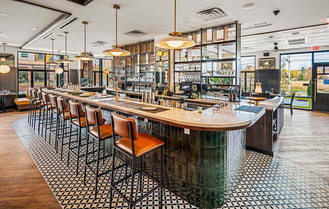 A bar with a long wooden counter and chairs.
