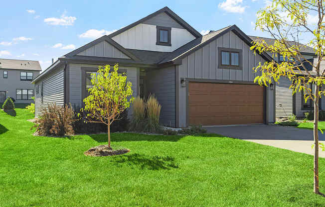 a home with a brown garage door and a green lawn