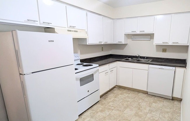 A kitchen with white appliances and cabinets.
