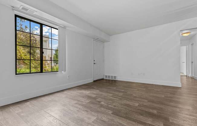 A room with a large window and wooden flooring.