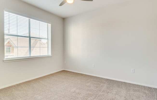 a bedroom with a ceiling fan and a window at Arioso apartments located at 3030 Claremont Dr in Grand Prairie, TX