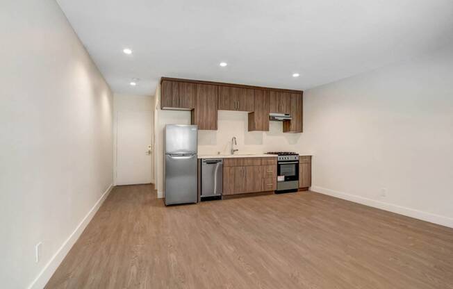 a kitchen with wooden cabinets and a stainless steel refrigerator