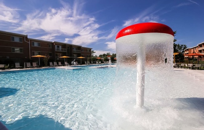 A water fountain in the middle of a pool.