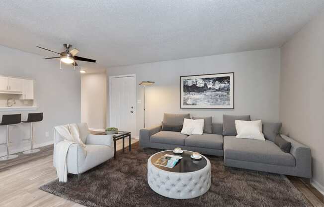 an open living room with a couch and a chair  at Eastwood Crossings, Kansas City, MO, 64129