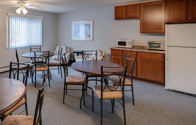 Community room with tables and chairs, a refrigerator, microwave, and toaster oven