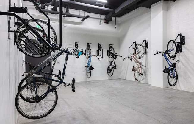 A room with a white wall and a black bicycle hanging on the wall at Skylar At Sunset Apartments, Los Angeles