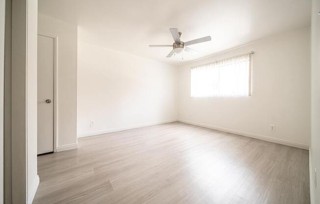 A room with a ceiling fan and a window.