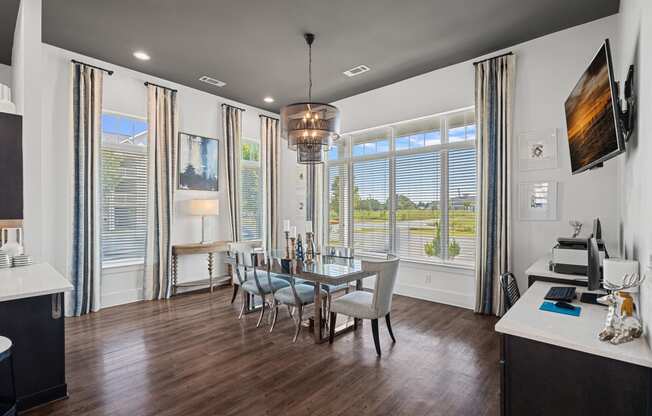 a dining room with a table and chairs and large windows