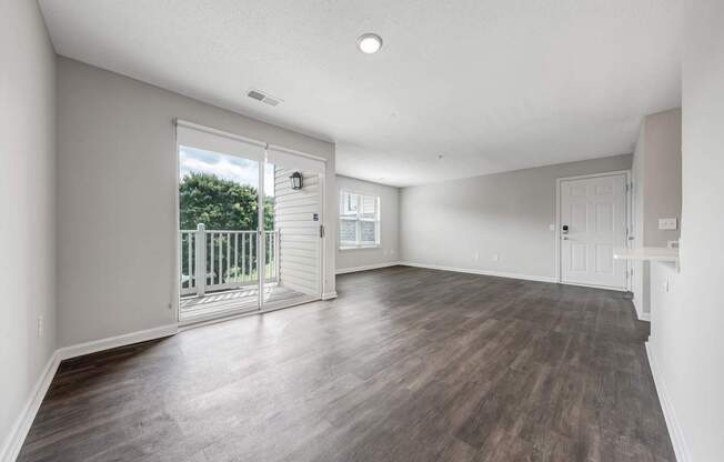 A room with a sliding glass door leading to a balcony.