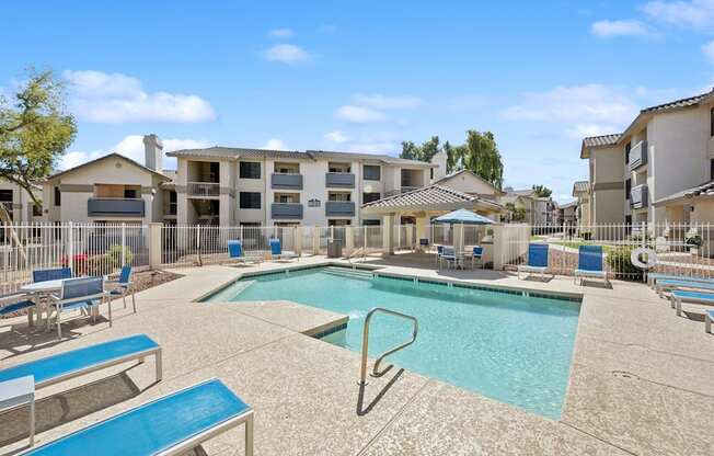 A swimming pool surrounded by sun loungers and chairs