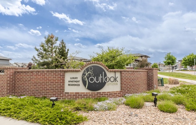 outook sign on brick wall with landscaping and sidewalk