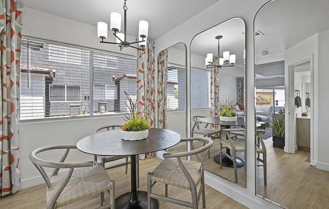 a dining area with a table and chairs and a large window