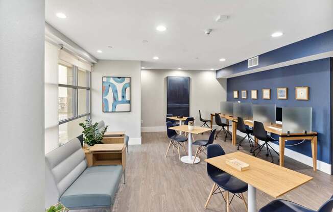 A room with a blue wall and a white ceiling with a painting on the wall at The Kitt at Warner Center Apartments, Woodland Hills, California