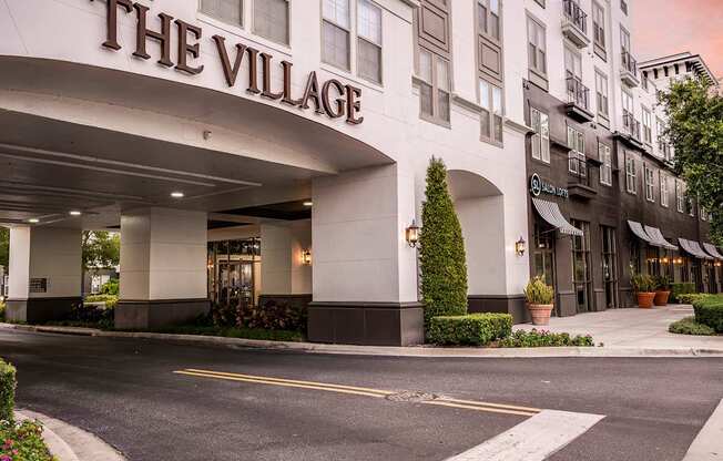 The front of a building called The Village with a white facade.