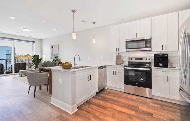 A modern kitchen with white cabinets and stainless steel appliances.
