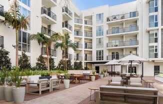 A white apartment building with a patio area in front.