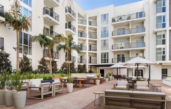 A white apartment building with a patio area in front.