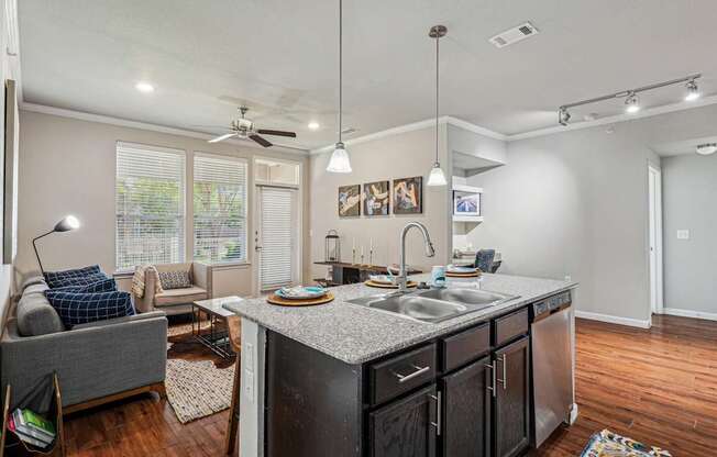 A kitchen with a grey couch and a counter.