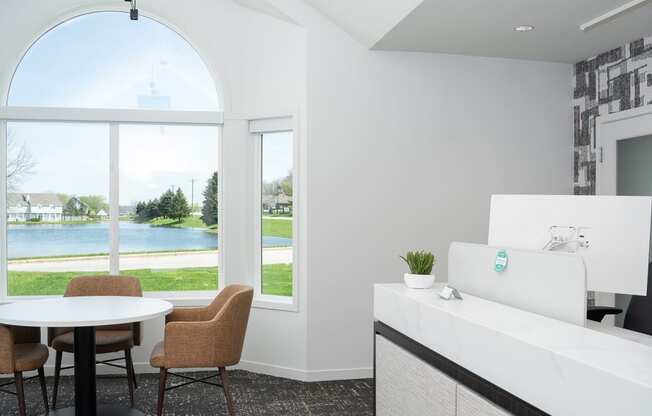 a living room with a view of a lake and a table and chairs