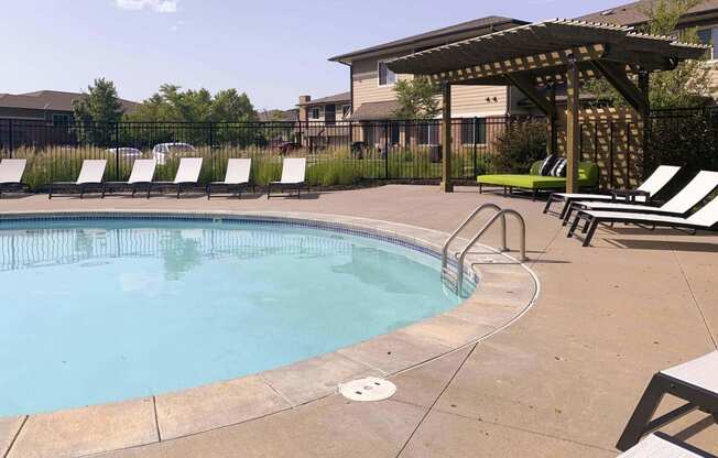 a resort style pool with lounge chairs and a gazebo