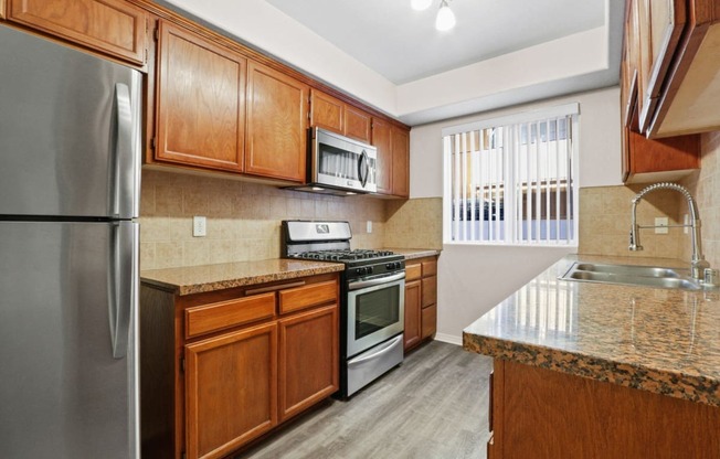 a kitchen with wooden cabinets and stainless steel appliances