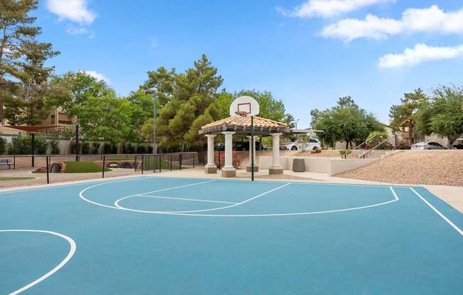 A basketball court with a basketball hoop and a gazebo.